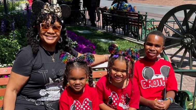 Gaylyn reserves as much of her free time to spend time with her two sons and three grandchildren. Gaylyn sitting on bench at Disneyland with her three grandchildren. Two girls, one boy
