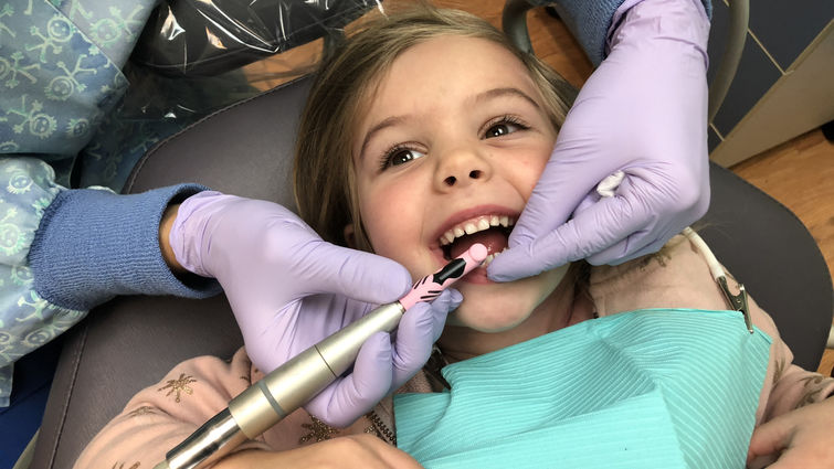 Young girl in dental chair getting dental examination