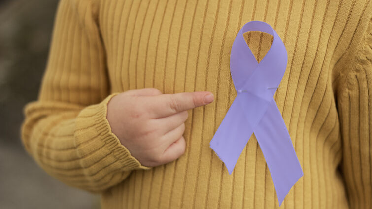 An epilepsy awareness ribbon pinned to child's sweater
