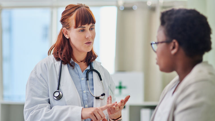 Shot of a doctor having a consultation with a young woman - stock photo