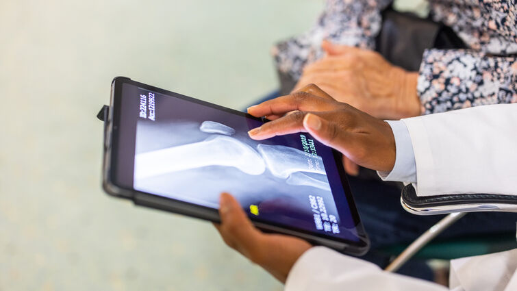 Close-up of a doctor sharing the treatment from the x-ray scan on digital tablet with a patient