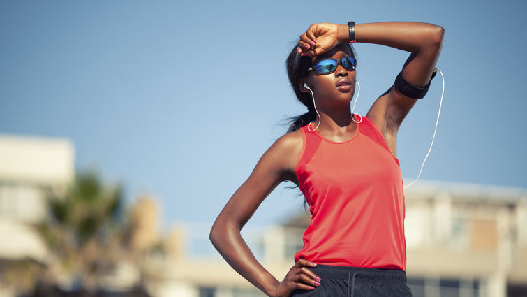 female runner shading herself from the sun