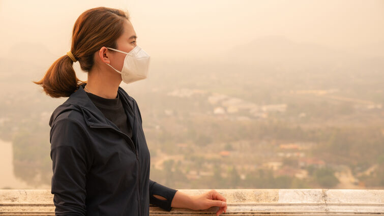 Asian woman wearing an N95 mask for protect bad air pollution. - stock photo