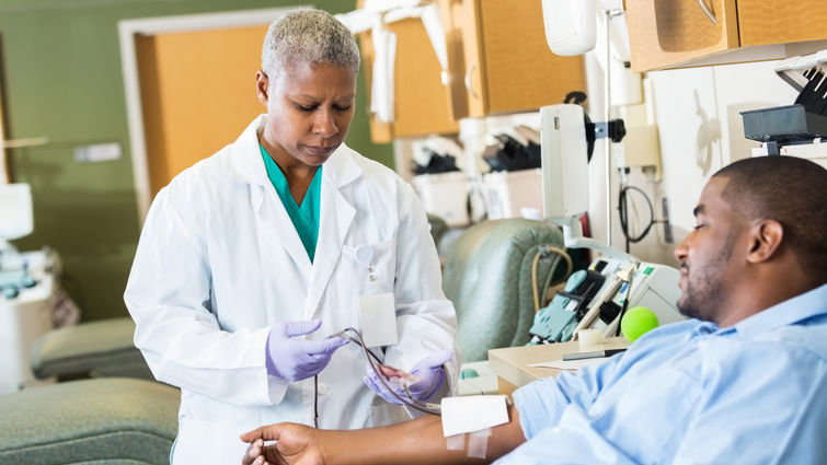 Senior phlebotomist checking on patient before taking blood sample