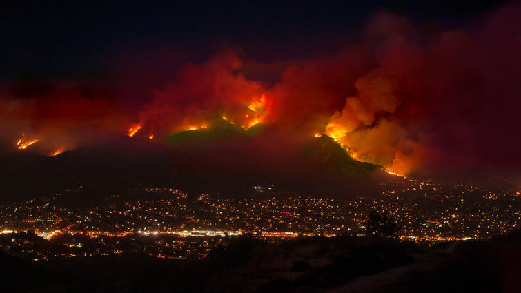 A wildfire burns the mountains endangering houses