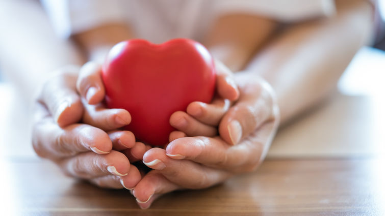 Woman and child holding red heart