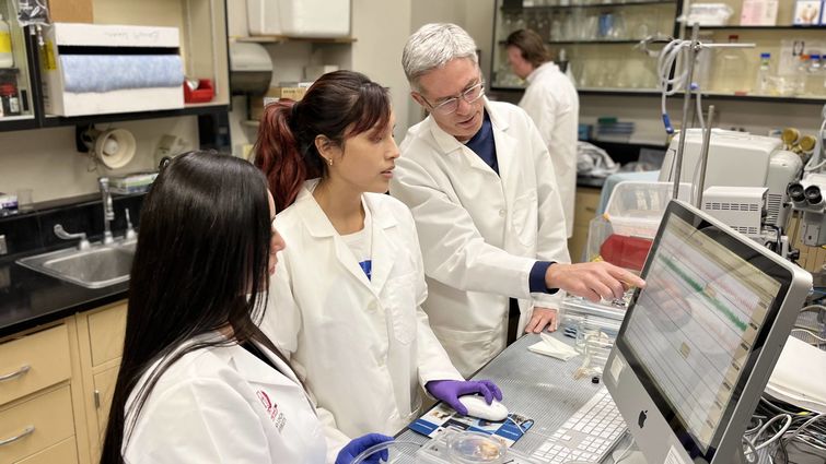 Dr. Arlin Blood conducts research with two students