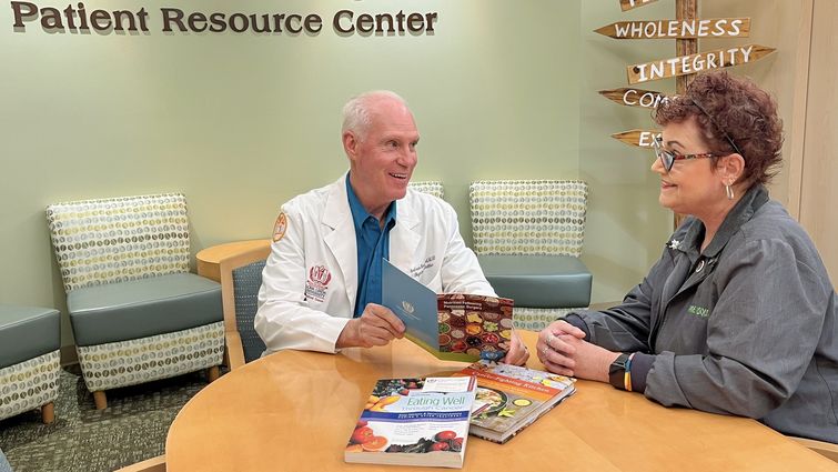 Andrew Woodward, MS, RD, CSO, an oncology nutritionist at Loma Linda University Cancer Center, speaks with a cancer survivor in the patient resource center.