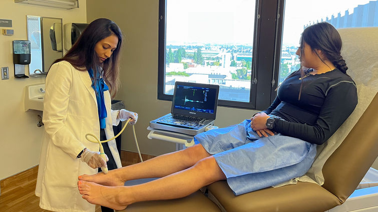 Pooja Swamy, MD, an interventional cardiologist and vascular specialist at Loma Linda University International Heart Institute, performs a vascular ultrasound on a woman’s leg.