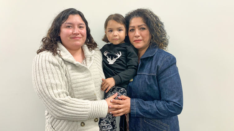 Estefania Morales (left), Giselle Morales (middle), Isabel Graciano (right) hispanic young mom embraces her mom and young daughter while standing together