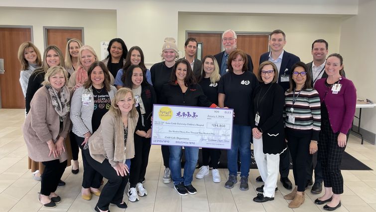 Loma Linda University Children's Hospital staff and representative from Spirit of Children stand together in a group for a photo with the check