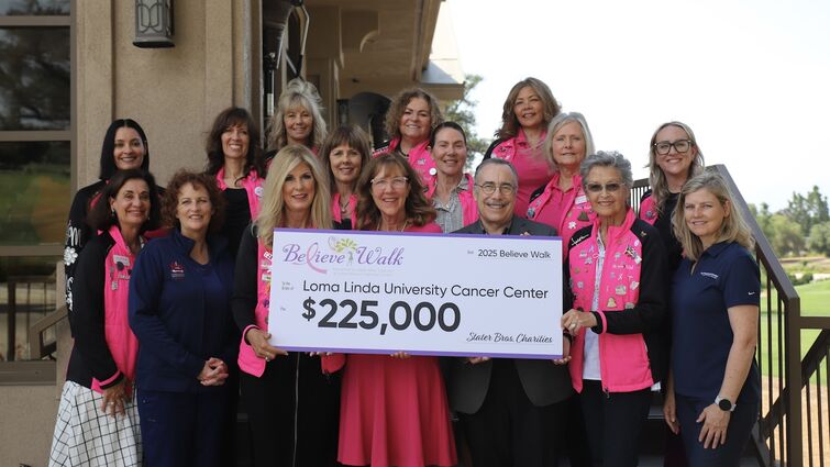 Funds will directly contribute to several innovative treatments that represent the future of cancer care. A group of people standing together on steps holding a check