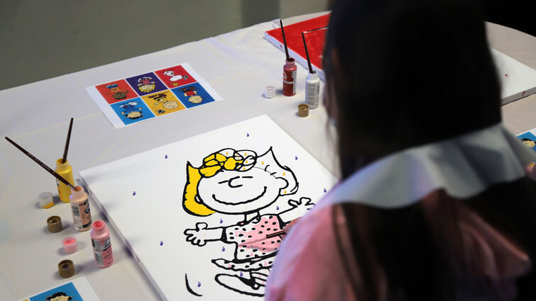Girl painting mural of Sally Brown