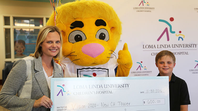 Max Hilliard, shown here with his mom, Tammy Hilliard, and pal Luke the Lion, launched a campaign to raise money for Loma Linda University Children's Hospital. Max and Tammy Hilliard hold their check for Loma Linda University Children’s Hospital.