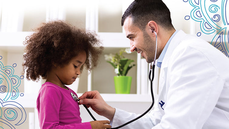 male doctor puts stethoscope on little girl's chest