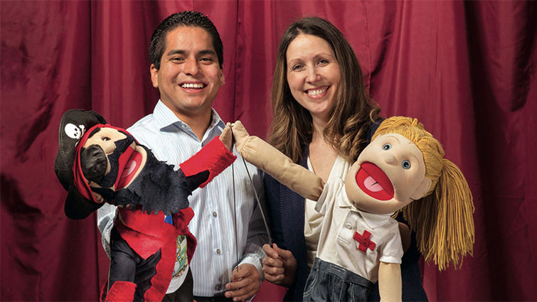 Marco Pasco-Rubio, a student in the School of Public Health and Ronda Spencer-Hwang, DrPH, display puppets they use as a part of their community health education efforts. lluh