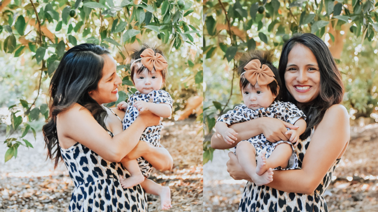 young mom smiling while holding four-month-old daughter