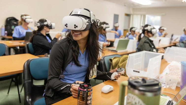 Nursing student wearing VR goggles in a classroom setting