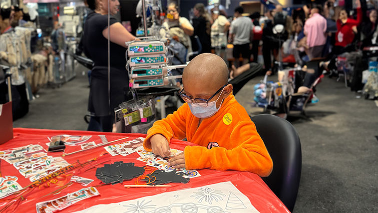 LLUCH pediatric male patient in Aang costume from avatar, sits at table and colors