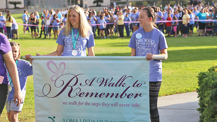 Two participants hold a banner for the "A Walk to Remember" event