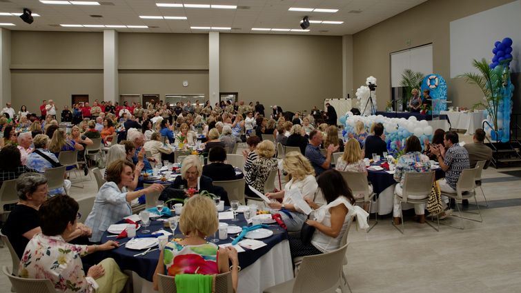 Annual Dishes for Wishes event at Loma Linda Korean Seventh-day Adventist Church in Redlands Wide shot of event space filled with guests sitting at their tables and officers lined up by the kitchen