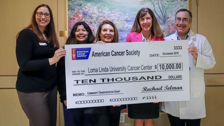 Five people hold giant presentation check