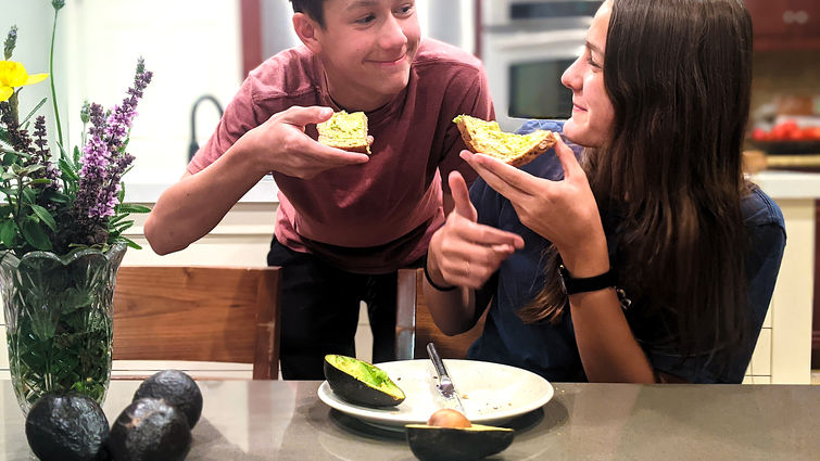Teens eating avocados