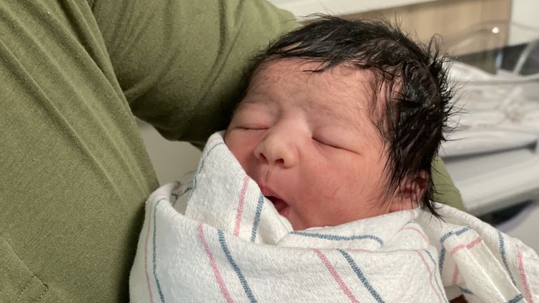 new years baby wrapped in bundle being held by dad