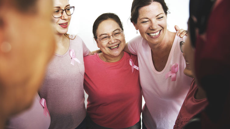 Group of women standing in a circle with their hands over each other's shoulders