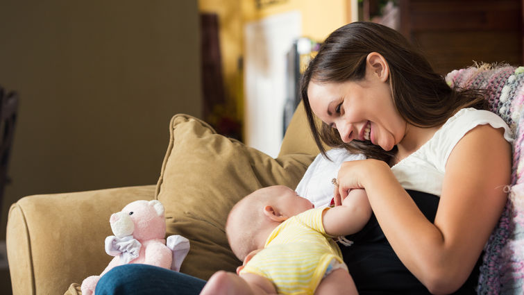 mom bonding with young baby on couch