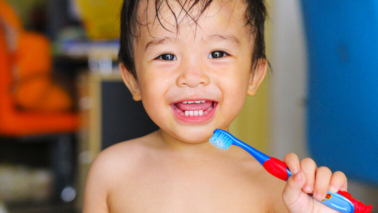 child holding tooth brush