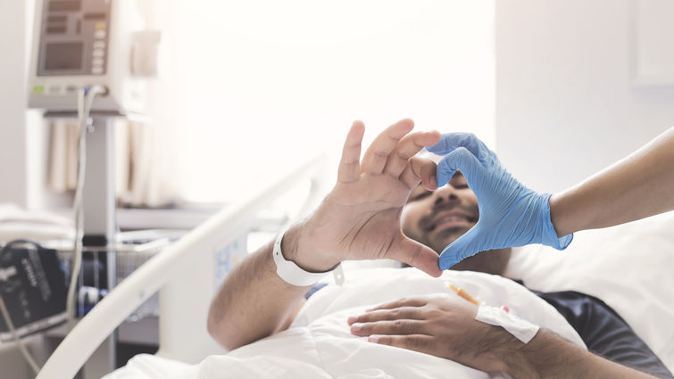 patient making heart shape out of fingers with doctor