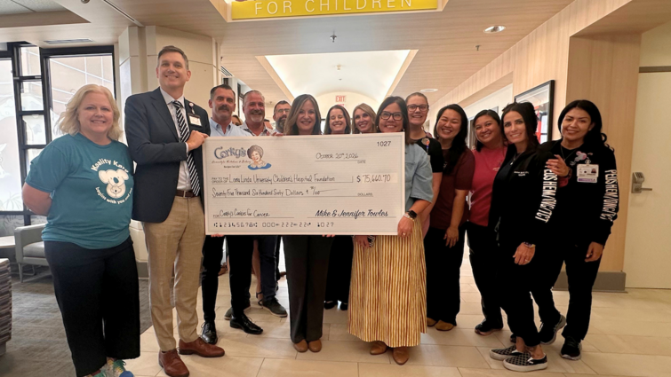 LLUCH staff poses for photo with large donation check.