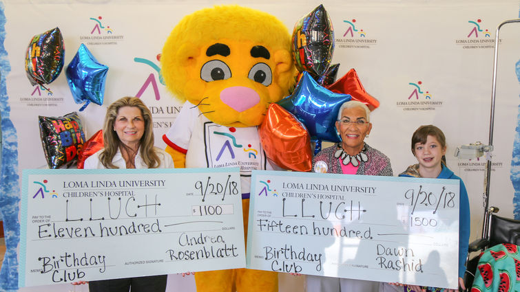 Andrea Rosenblatt (left) and Dawn Rashid presented their Birthday Club donation to LLUCH alongside Luke the Lion and LLUCH patient, Codi Pelton, 13, of Desert Hot Springs on Thursday, September 20.
