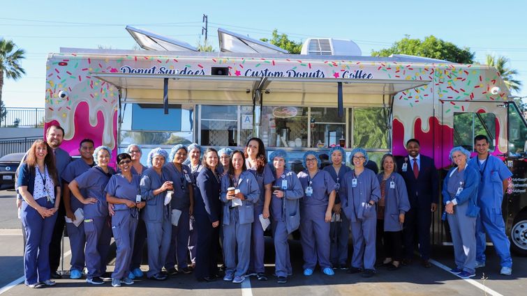 staff group photo in front of doughnut truck