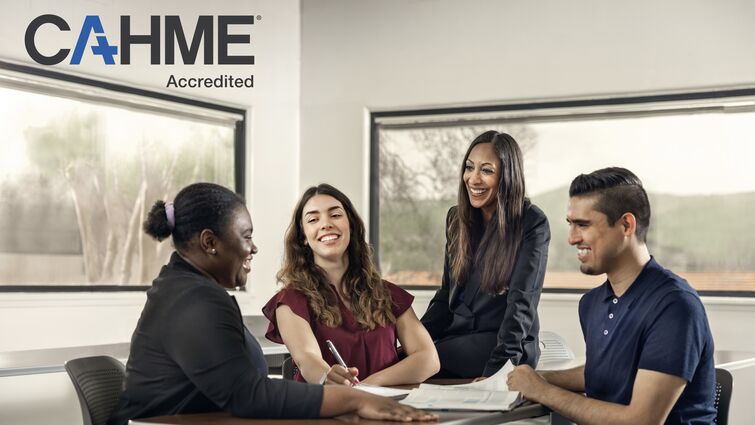 three college students and a professor sitting around a table conversing.
