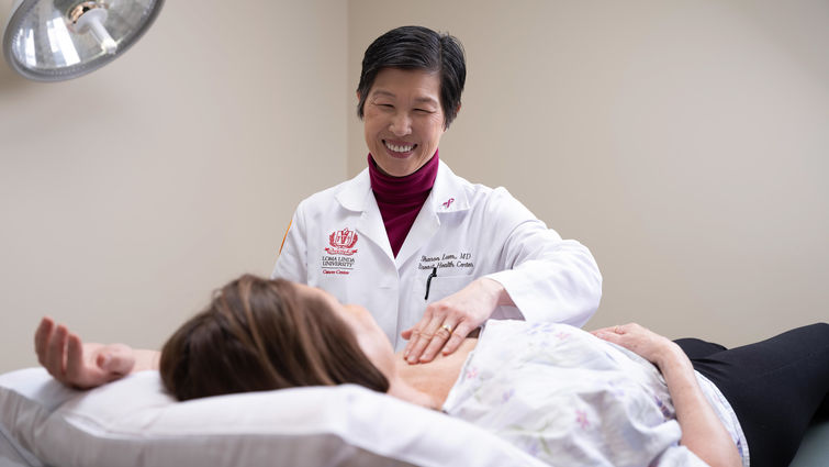 Dr. Lum performs a breast exam on a patient