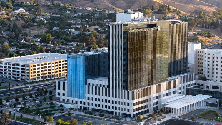 LLU hospital exterior at sunset with hills in the background