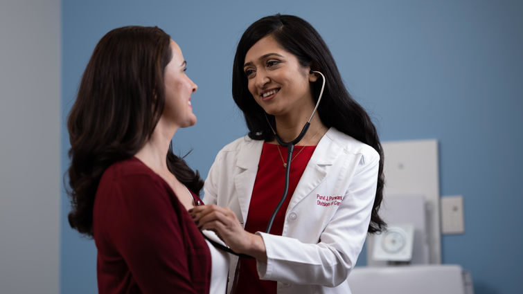 Dr. Parwani checks patient's heart beat with a stethoscope