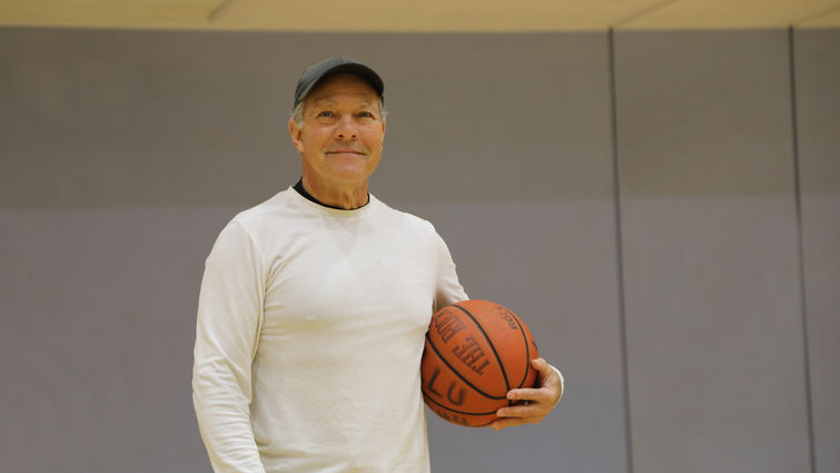 Enrique Gonzalez continues to play recreational sports after a minimally invasive back surgery. Enrique Gonzalez smiling, holding a basketball