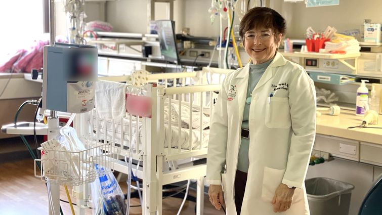 Dr. Elba Simon-Fayard stands in front of NICU crib