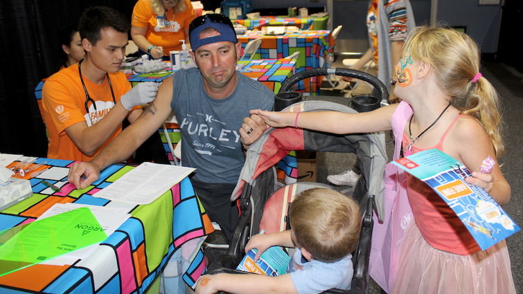 Yucaipa resident Nicholas Pastorino gets support from his two children as he braved his annual flu shot during the Family Health Fair, Sunday Oct. 29.