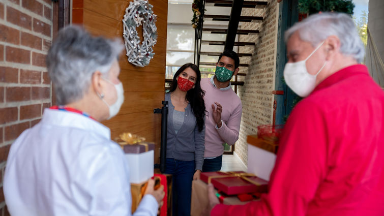 Parents visiting children for the holidays and everyone is wearing a mask