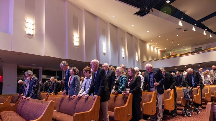 individuals standing in prayer in a chapel