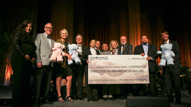 hospital administrators and san manuel tribe representatives stand with check