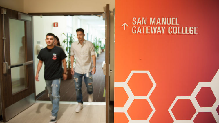 College interior signage with students walking by