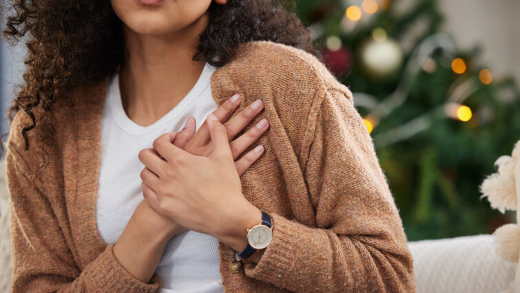 a woman uses both hands to hold her chest