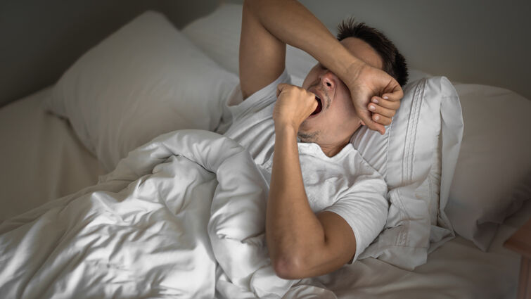 Tired man yawning and waking up early morning