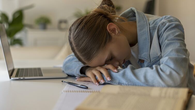 Exhausted Young Student Girl Sleeping on Desk While Studying at Home