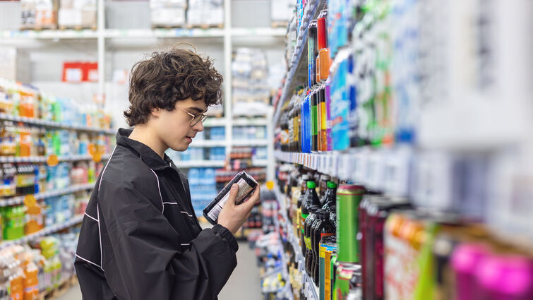 boy choosing beverage in supermarket